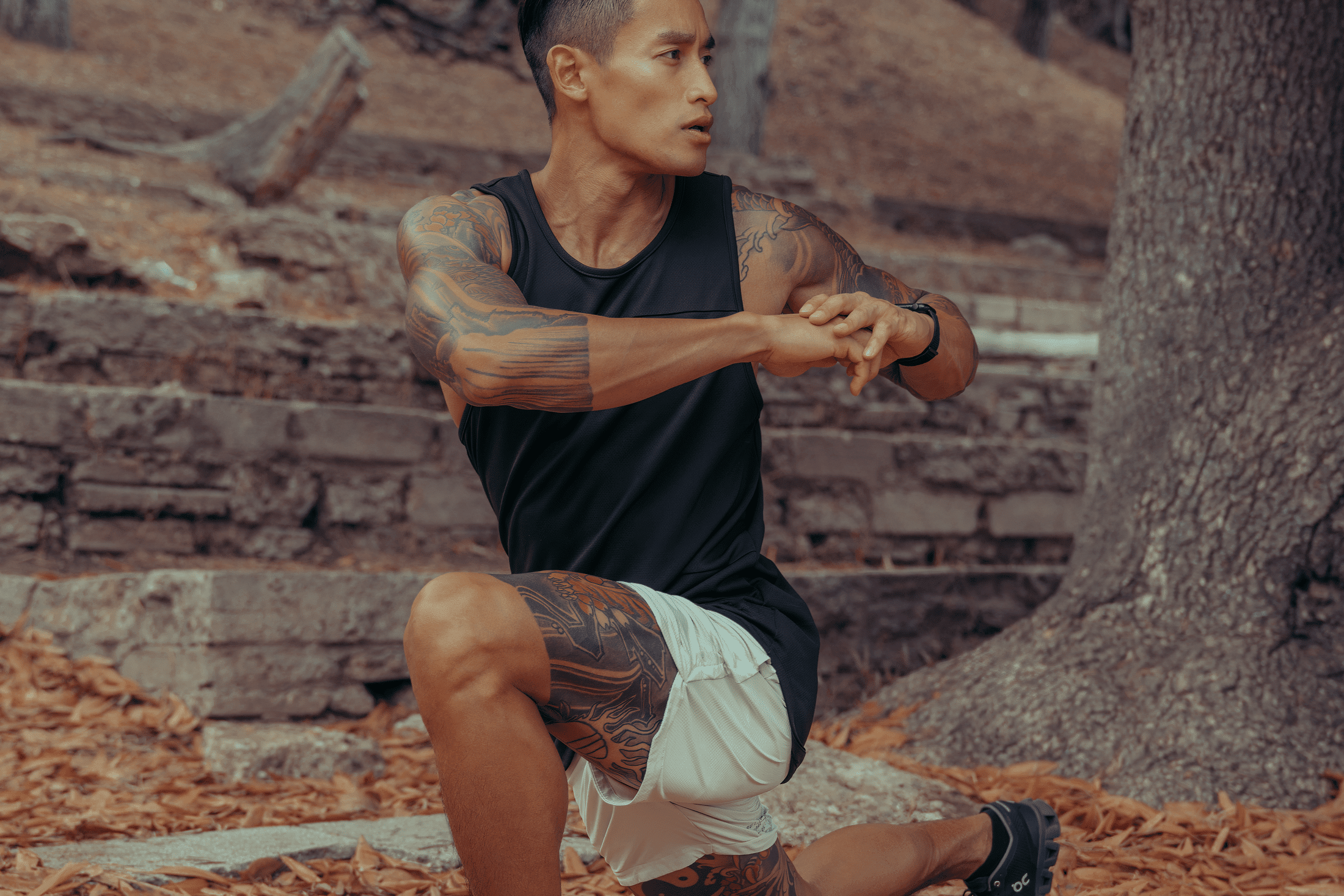 Man with bicep tattoos stretching