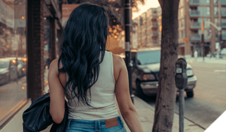 Photo of a woman's back as she walks down the street